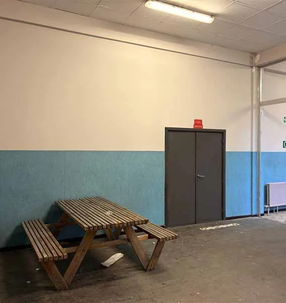 un couloir avec à gauche une table en bois et la porte grise qu'on veut repeindre